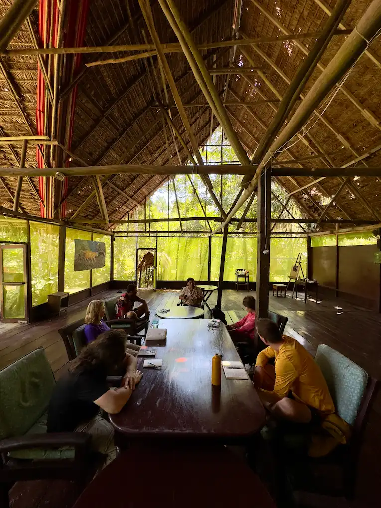 Guests sitting with the shaman at a table in the main house